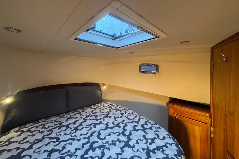 Hula Moon Yacht Photos Pics Cozy cabin interior of 2006 Mainship 34 Trawler with skylight and patterned bedding.