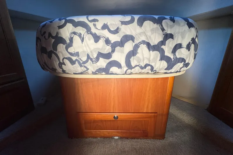 Hula Moon Yacht Photos Pics 2006 Mainship 34 Trawler cabin with patterned bedding and wooden storage.