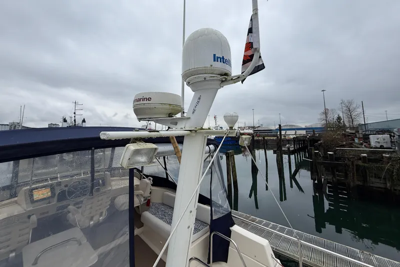 Hula Moon Yacht Photos Pics 2006 Mainship 34 Trawler with navigation equipment docked at a marina under cloudy skies.