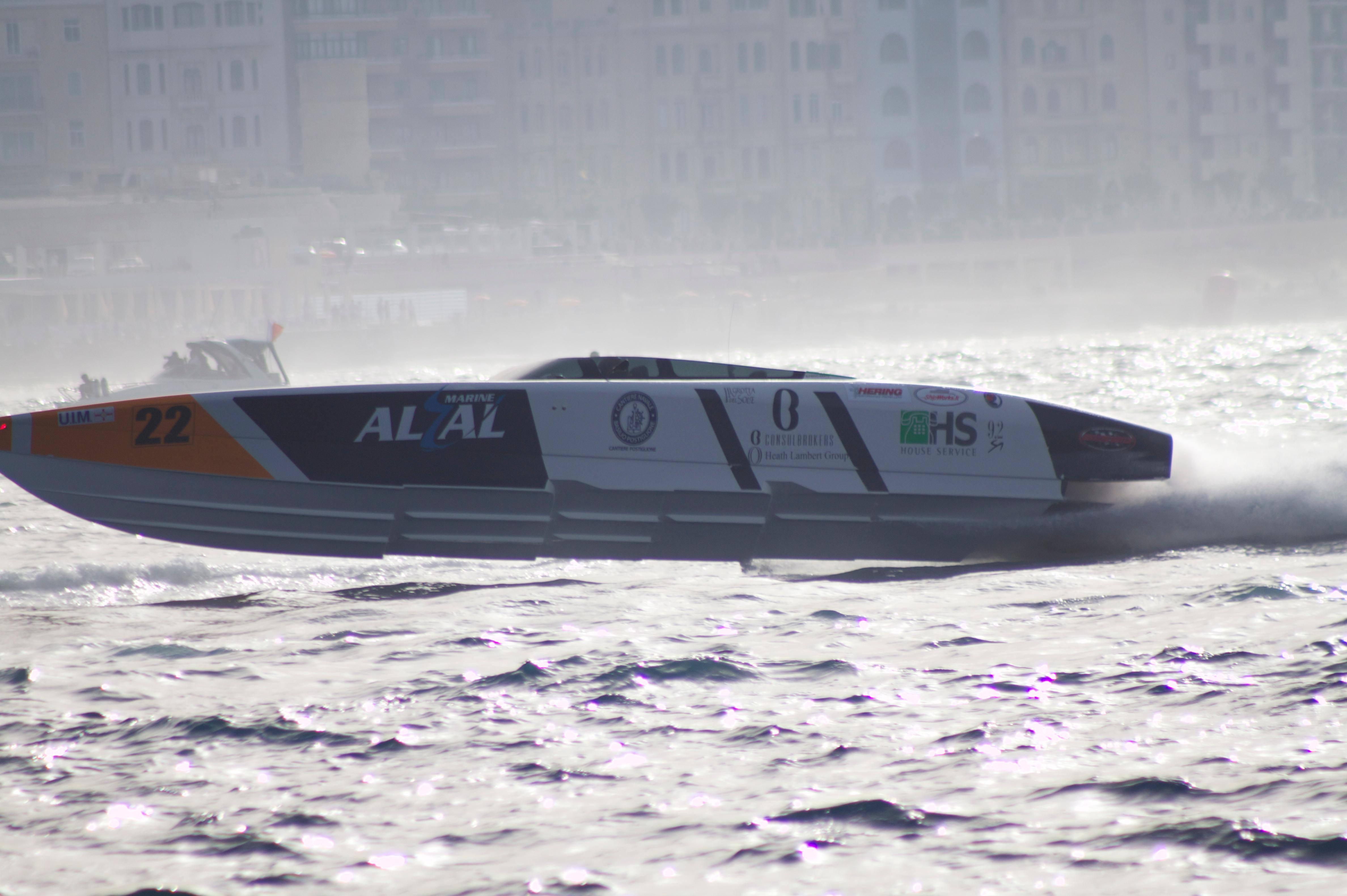 2021 Outerlimits 40 SV powerboat racing on choppy water, side view.
