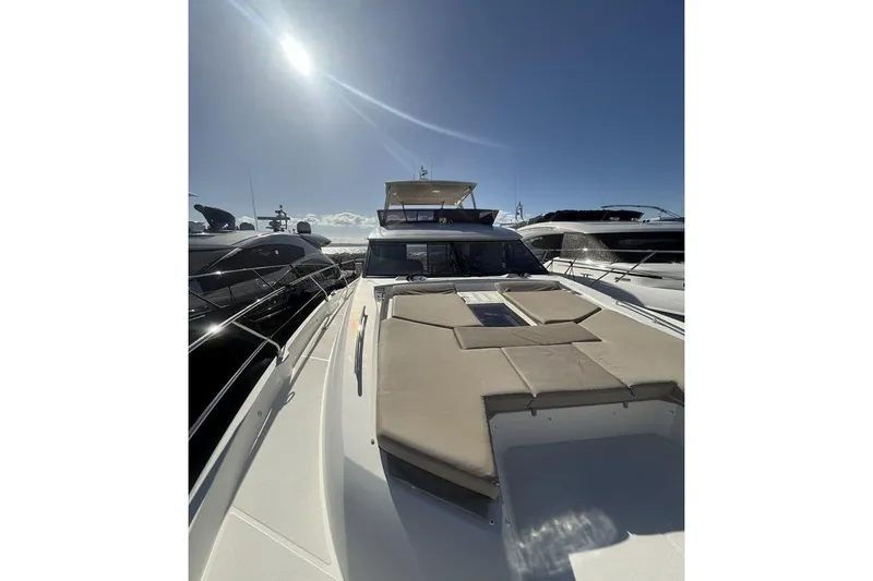  Yacht Photos Pics 2022 Prestige 590 yacht under bright sun, docked among other luxury boats.