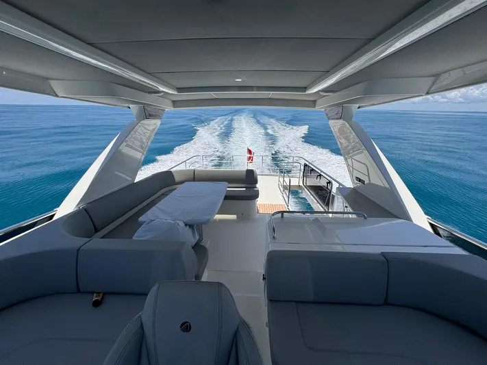  Yacht Photos Pics Luxurious 2024 Absolute 58 Navetta yacht cruising on open sea with elegant seating area.