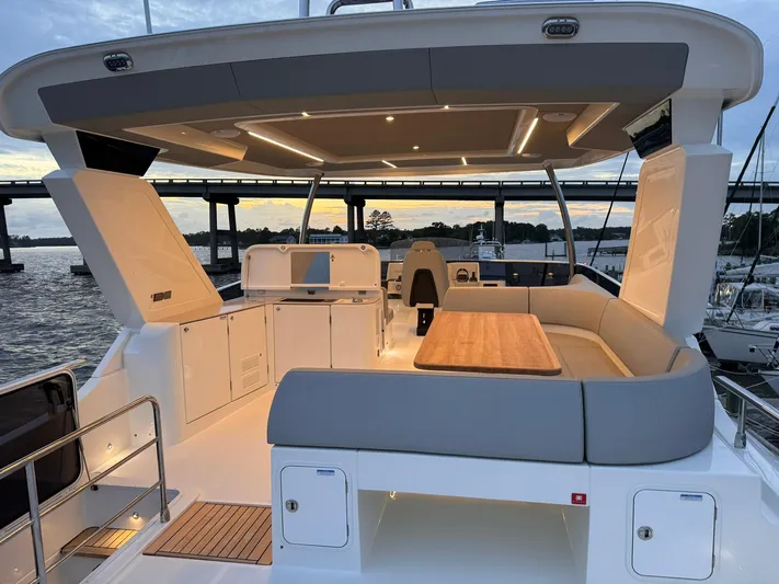  Yacht Photos Pics Luxurious 2024 Absolute 58 Navetta yacht with spacious deck and modern seating at sunset.