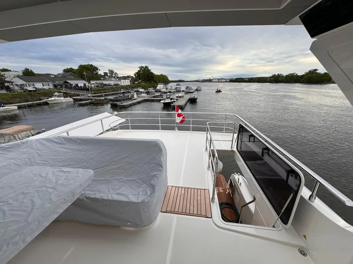  Yacht Photos Pics 2024 Absolute 58 Navetta yacht deck overlooking serene river and marina.