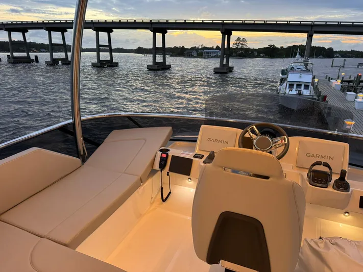  Yacht Photos Pics 2024 Absolute 58 Navetta yacht interior with helm, overlooking serene waters and bridge at sunset.