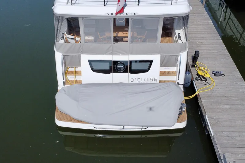  Yacht Photos Pics 2024 Absolute 58 Navetta yacht docked, rear view with covered equipment and visible deck.