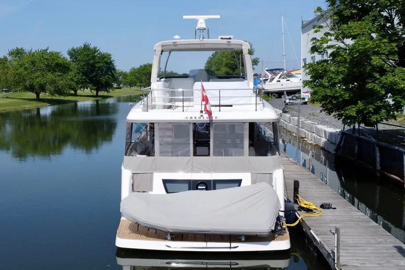  Yacht Photos Pics 2024 Absolute 58 Navetta yacht docked in a serene canal setting.