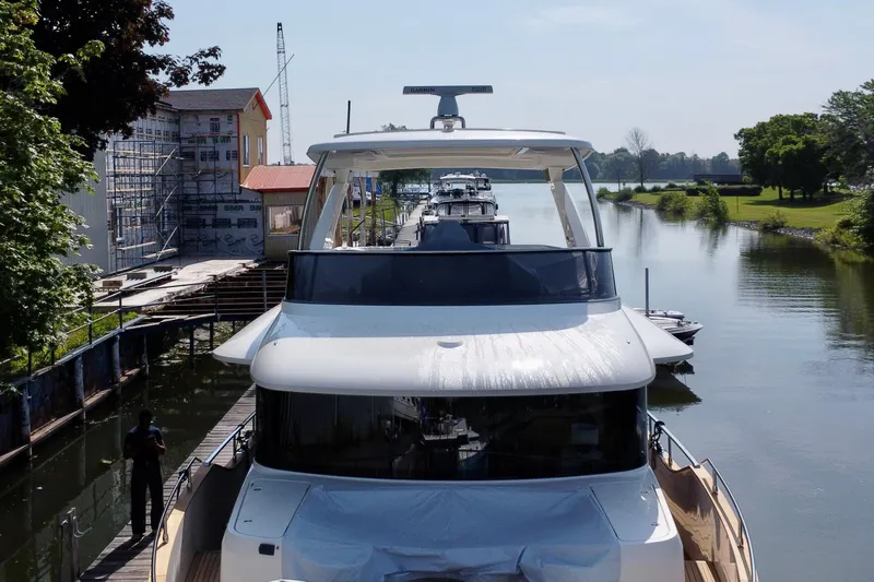  Yacht Photos Pics 2024 Absolute 58 Navetta yacht docked in a serene canal setting.