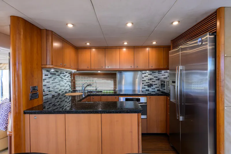 Yacht Photos Pics Luxurious kitchen interior of a 2006 Sunseeker 75 Yacht with modern appliances and wood cabinetry.