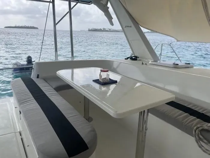 Sv Althea Yacht Photos Pics Leopard 45/47 catamaran deck with seating, table, and ocean view, year 2000.