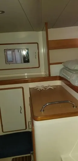 Sv Althea Yacht Photos Pics Interior of 2000 Leopard 45/47 yacht with wooden cabinetry and bedding.
