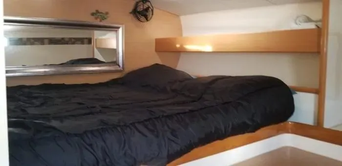 Sv Althea Yacht Photos Pics Cozy cabin interior of 2000 Leopard 45/47 yacht with bed and mirror.