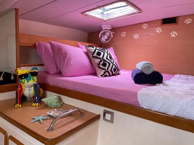 Sv Althea Yacht Photos Pics Cozy Leopard 45/47 yacht cabin with pink bedding, decorative pillows, and colorful accents.