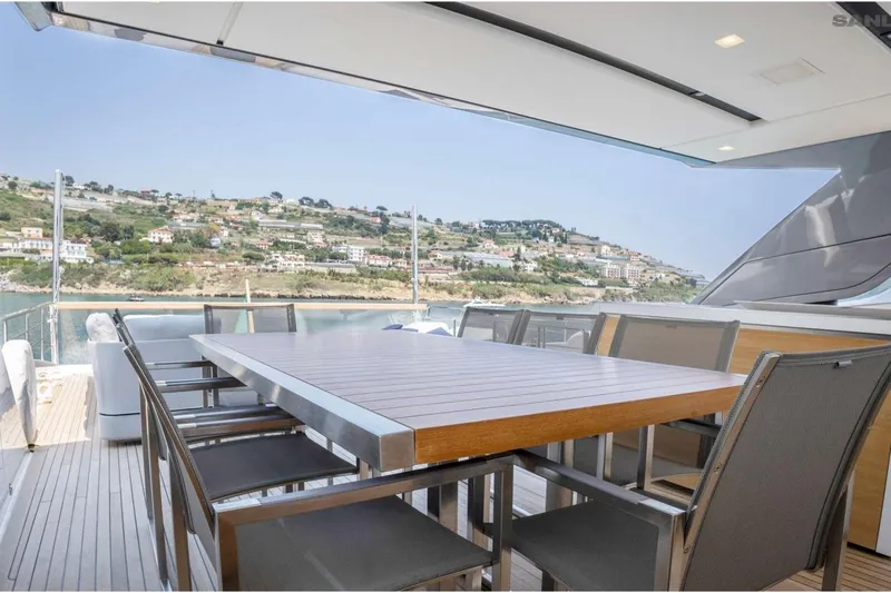 Aman - Sanlorenzo Sl96 Yacht Photos Pics Outdoor dining area on 2016 Sanlorenzo SL96 yacht with scenic coastal view.