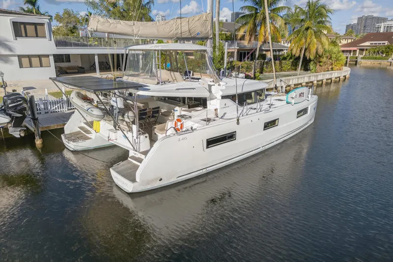 White Heron Yacht Photos Pics 2021 Lagoon 46 Owner's Version catamaran docked in a serene canal setting.