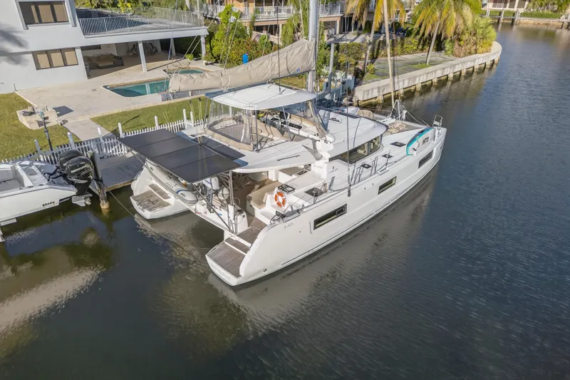 White Heron Yacht Photos Pics 2021 Lagoon 46 Owner's Version catamaran docked in a serene waterfront setting.