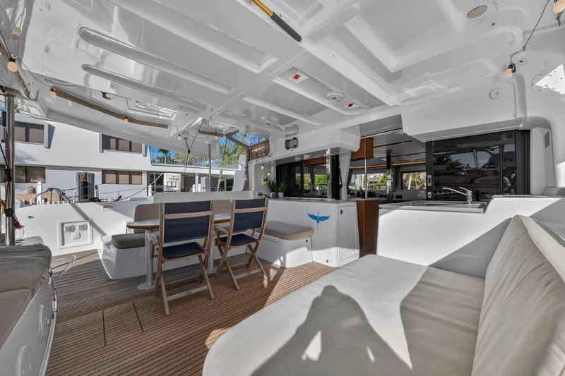 White Heron Yacht Photos Pics Spacious interior of 2021 Lagoon 46 Owner's Version catamaran with modern seating and dining area.