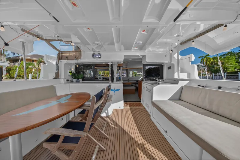 White Heron Yacht Photos Pics Spacious interior of 2021 Lagoon 46 Owner's Version catamaran with elegant seating and dining area.