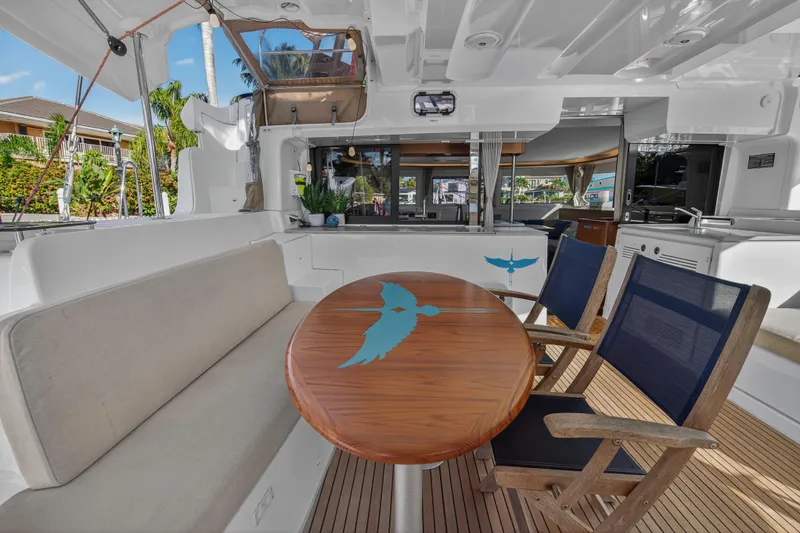 White Heron Yacht Photos Pics Luxurious 2021 Lagoon 46 yacht interior with elegant seating and wooden table.