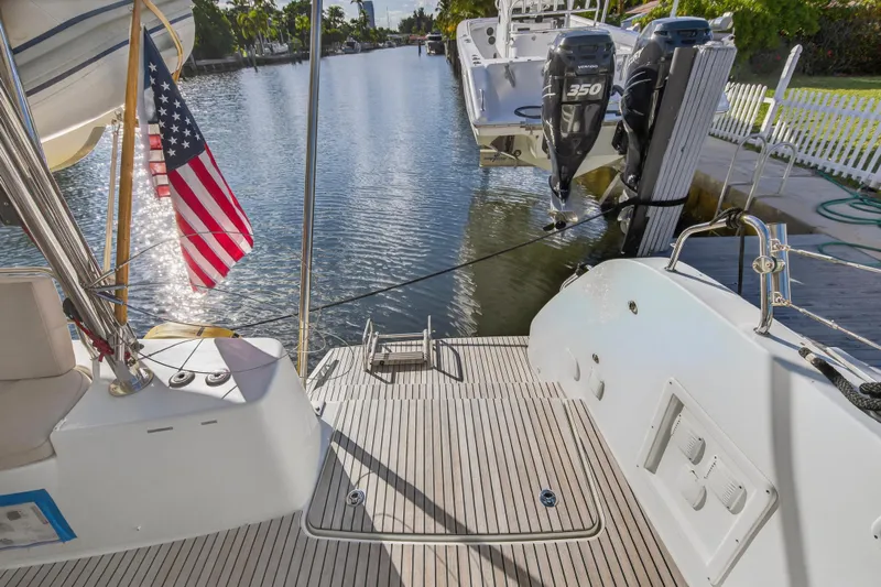 White Heron Yacht Photos Pics Lagoon 46 Owner's Version 2021 yacht with American flag, docked by a serene canal.