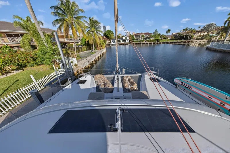 White Heron Yacht Photos Pics Lagoon 46 Owner's Version 2021 catamaran docked by a scenic canal with palm trees.