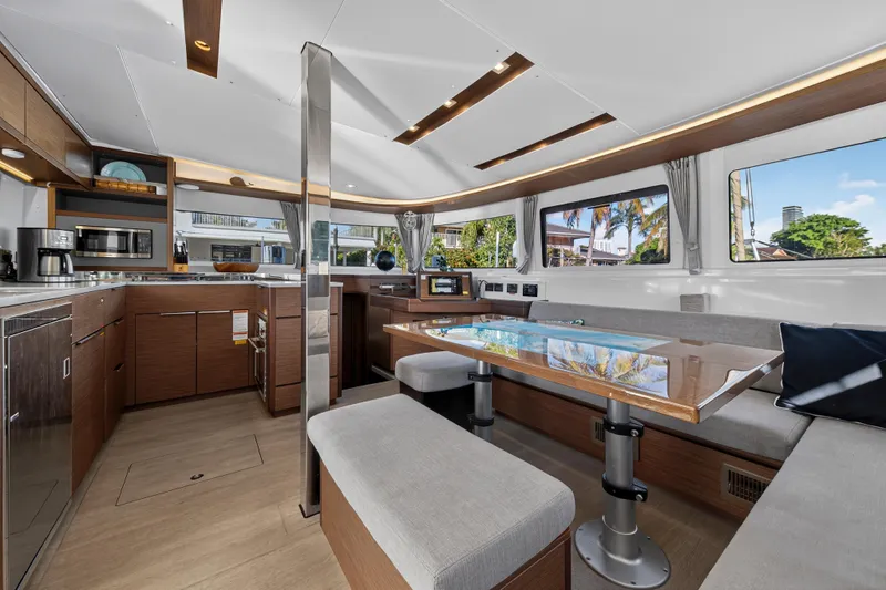 White Heron Yacht Photos Pics Luxurious interior of 2021 Lagoon 46 Owner's Version catamaran with modern kitchen and seating area.