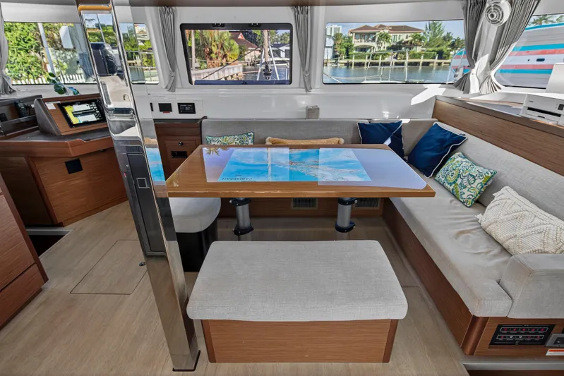 White Heron Yacht Photos Pics Luxurious interior of 2021 Lagoon 46 Owner's Version catamaran with modern seating and navigation area.