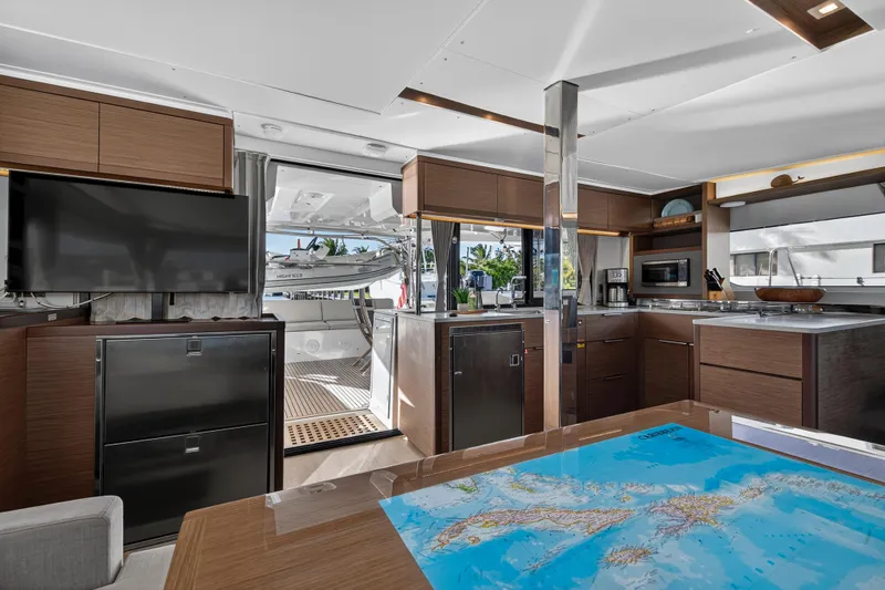 White Heron Yacht Photos Pics Luxurious interior of 2021 Lagoon 46 Owner's Version yacht with modern kitchen and map table.