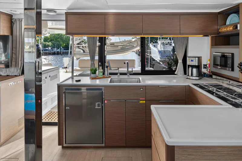 White Heron Yacht Photos Pics Modern kitchen interior of 2021 Lagoon 46 Owner's Version yacht, featuring sleek appliances and waterfront view.