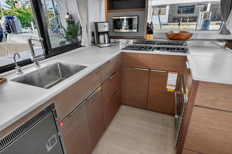White Heron Yacht Photos Pics Modern kitchen in 2021 Lagoon 46 Owner's Version yacht with sleek appliances and wood cabinetry.