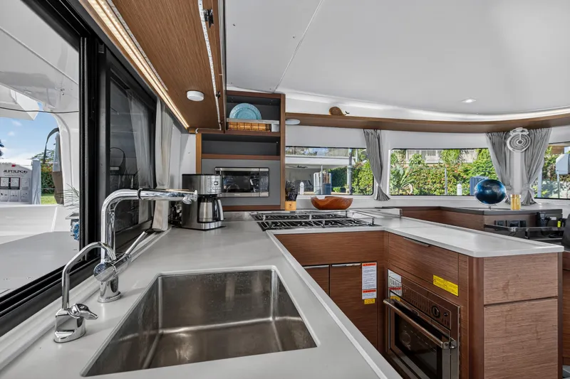 White Heron Yacht Photos Pics Modern kitchen interior of 2021 Lagoon 46 Owner's Version catamaran, featuring sleek design and appliances.