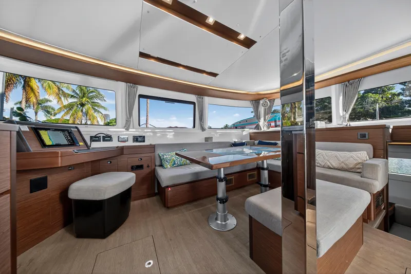 White Heron Yacht Photos Pics Luxurious interior of 2021 Lagoon 46 Owner's Version catamaran with modern seating and navigation area.