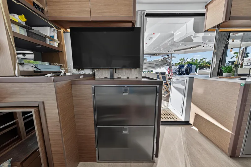 White Heron Yacht Photos Pics Interior of 2021 Lagoon 46 Owner's Version yacht with modern kitchen and outdoor view.