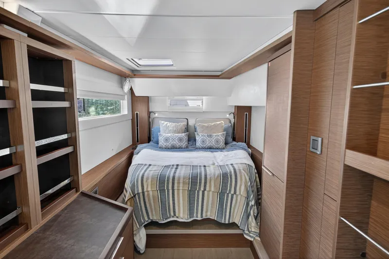 White Heron Yacht Photos Pics Luxurious bedroom interior of 2021 Lagoon 46 Owner's Version yacht with modern wood finishes.