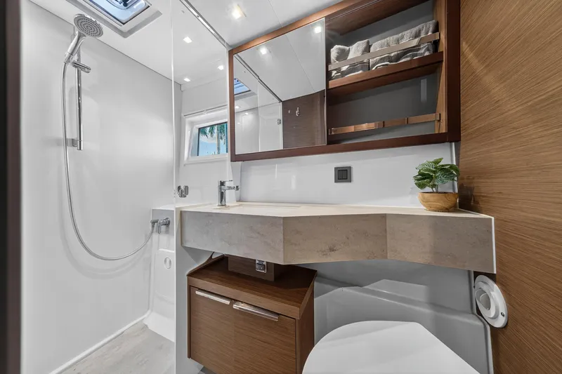 White Heron Yacht Photos Pics Modern bathroom in 2021 Lagoon 46 Owner's Version yacht, featuring sleek design and wood accents.