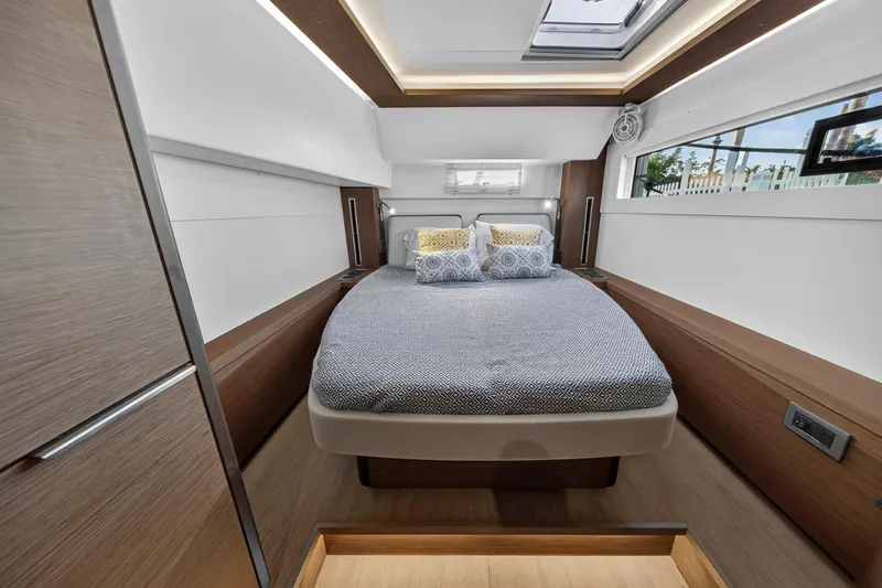 White Heron Yacht Photos Pics Luxurious bedroom interior of 2021 Lagoon 46 Owner's Version yacht, featuring modern design and cozy bedding.