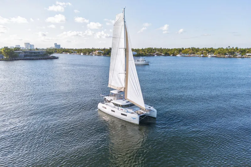White Heron Yacht Photos Pics Sailing Lagoon 46 Owner's Version catamaran, 2021 model, on calm waters under clear skies.