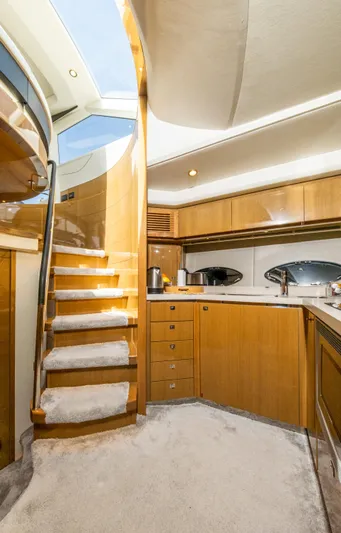  Yacht Photos Pics Luxurious 2016 Princess V72 yacht interior with wooden cabinetry and carpeted stairs.