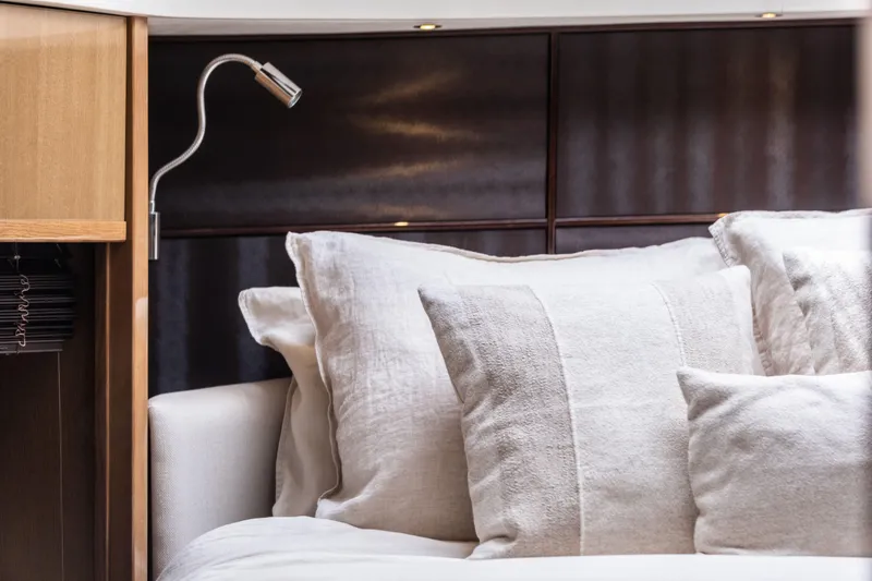  Yacht Photos Pics Luxurious bedroom interior on a 2016 Princess V72 yacht, featuring plush pillows and modern lighting.