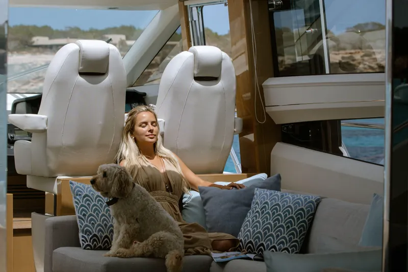  Yacht Photos Pics Woman relaxing with dog on 2016 Princess V72 yacht interior.