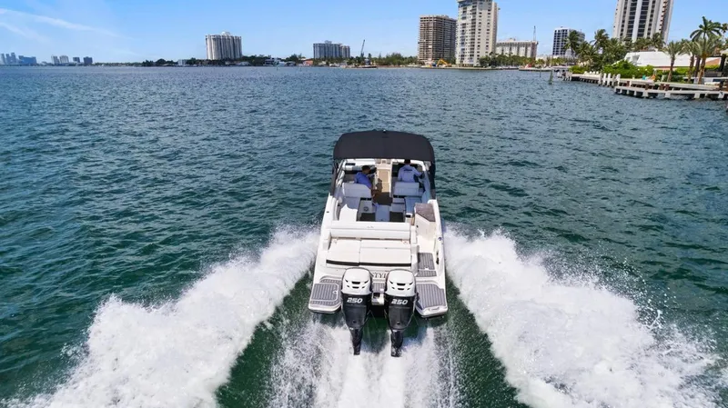  Yacht Photos Pics 2018 Sea Ray SDX 290 boat cruising on open water near city skyline.