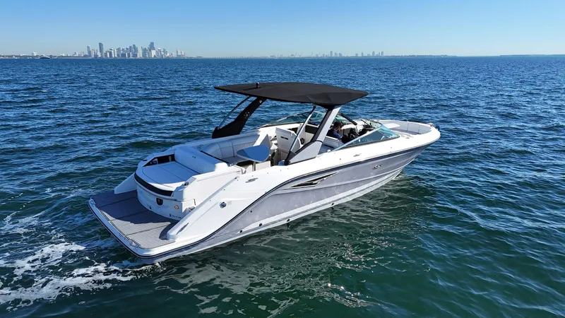  Yacht Photos Pics 2019 Sea Ray SLX 310 boat cruising on open water with city skyline in background.