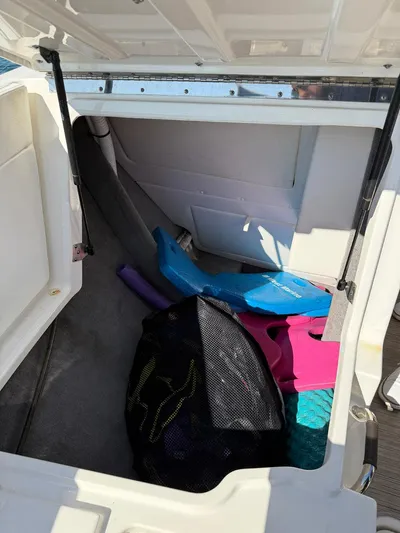  Yacht Photos Pics Storage compartment of a 2019 Sea Ray SLX 310 boat with various items inside.