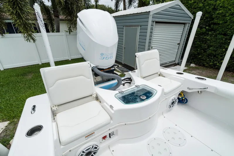  Yacht Photos Pics 2021 Everglades 243 Center Console boat with seating and outboard motor in a backyard setting.