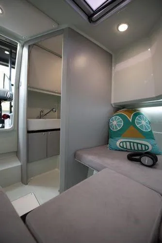  Yacht Photos Pics 2024 XO Boats DFNDR 9 interior with modern seating, colorful pillow, and compact kitchenette.