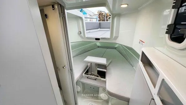  Yacht Photos Pics 2024 XO Boats DFNDR 9 cabin interior with seating and table.