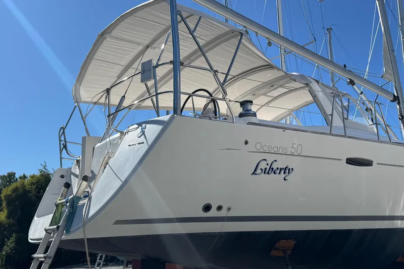 Liberty Yacht Photos Pics 2011 Beneteau Oceanis 50 sailboat named Liberty, docked under clear blue sky.