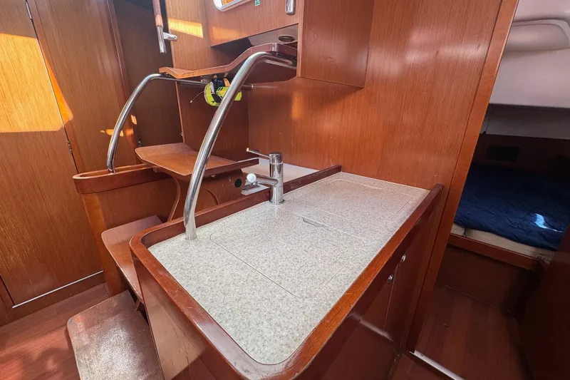Liberty Yacht Photos Pics Interior of 2011 Beneteau Oceanis 50 yacht with wooden cabinetry and compact kitchen area.