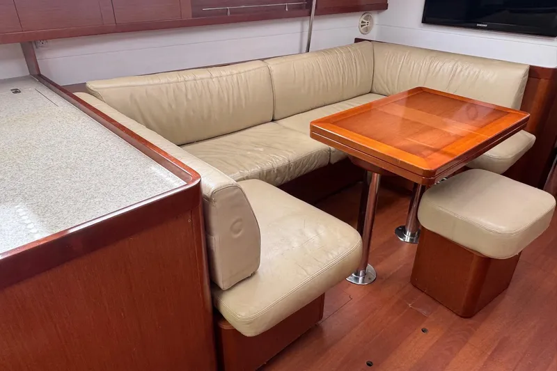 Liberty Yacht Photos Pics Interior of 2011 Beneteau Oceanis 50 yacht with beige leather seating and wooden table.