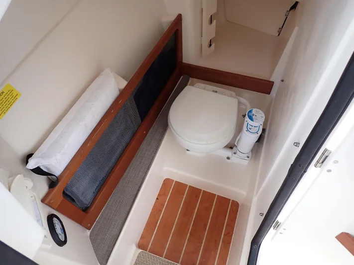  Yacht Photos Pics 2019 Grady-White Freedom 275 boat interior with toilet and storage compartment.